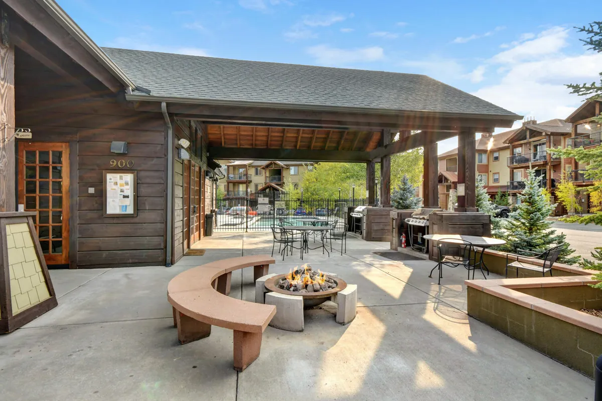 A welcoming outdoor amenity area with a fire pit, benches, and grill setup surrounded by natural scenery. The inviting arrangement suggests convivial evenings spent socializing and unwinding after a day of adventure.